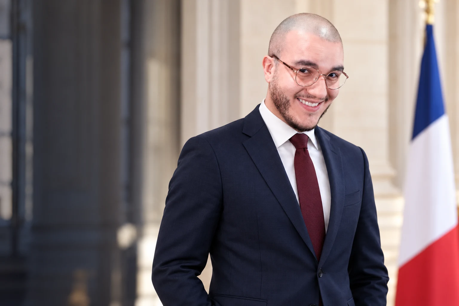 Portrait généré d’Akaruu en costume bleu nuit, chemise blanche et cravate bordeaux pour la campagne parodique